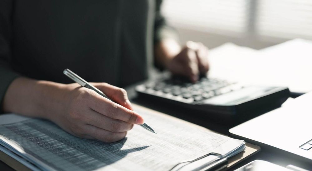 Person writing notes on a notebook with