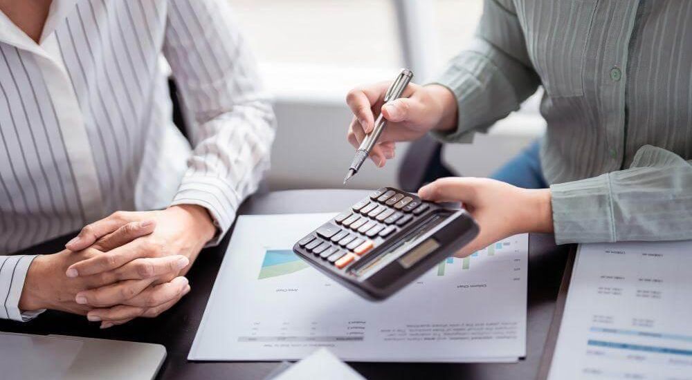 Two people review costs at a table with