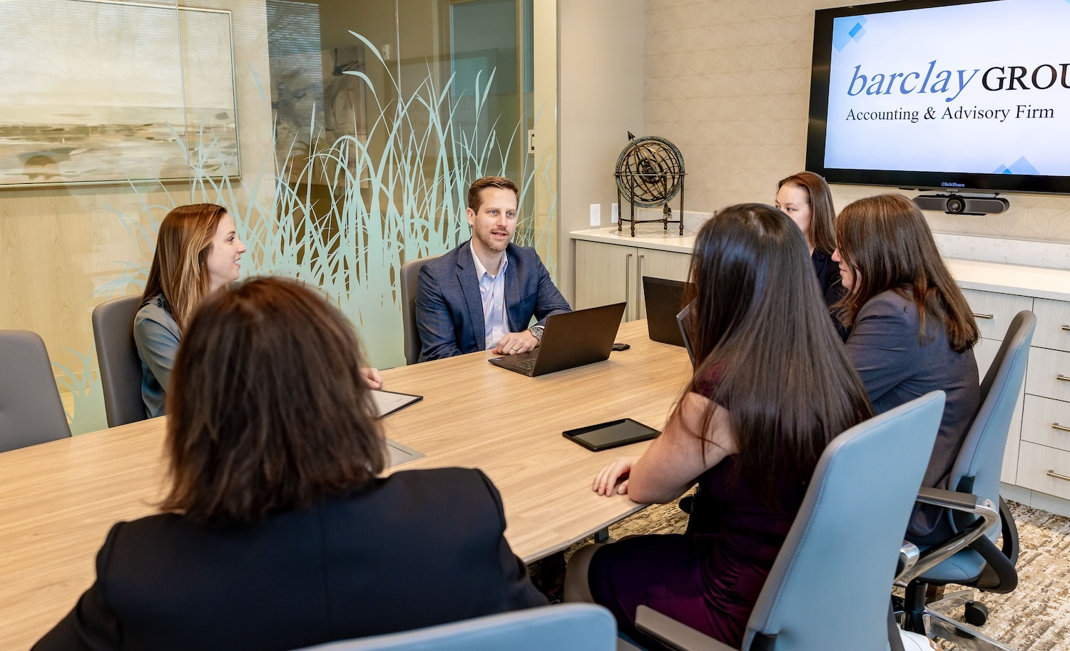 Business meeting at Barclay Group office, professionals discussing accounting strategies around a conference table.
