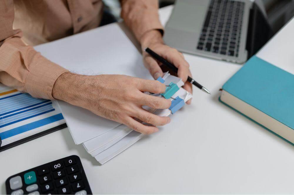 Person at desk with laptop and papers,